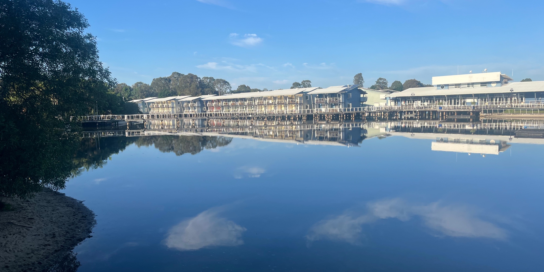 Marina-side buildings reflected in calm water at Couran Cove on South Stradbroke Island